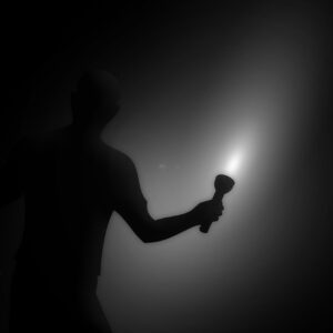 Schematische Darstellung Mensch mit Taschenlampe im Dunkeln - symbolisch für das Thema Symbolisches Bild für das Thema Vorsorge Blackout