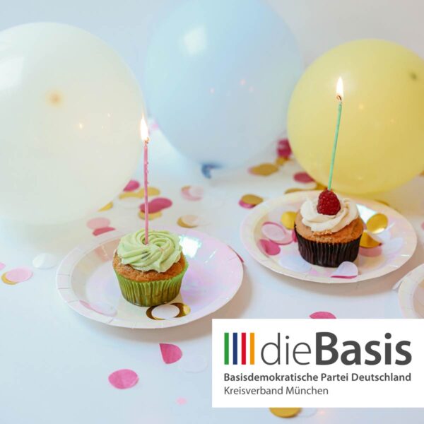 Zwei Geburtstags-Muffins mit Kerze und Luftballons und dieBasis Kreisverband München Logo